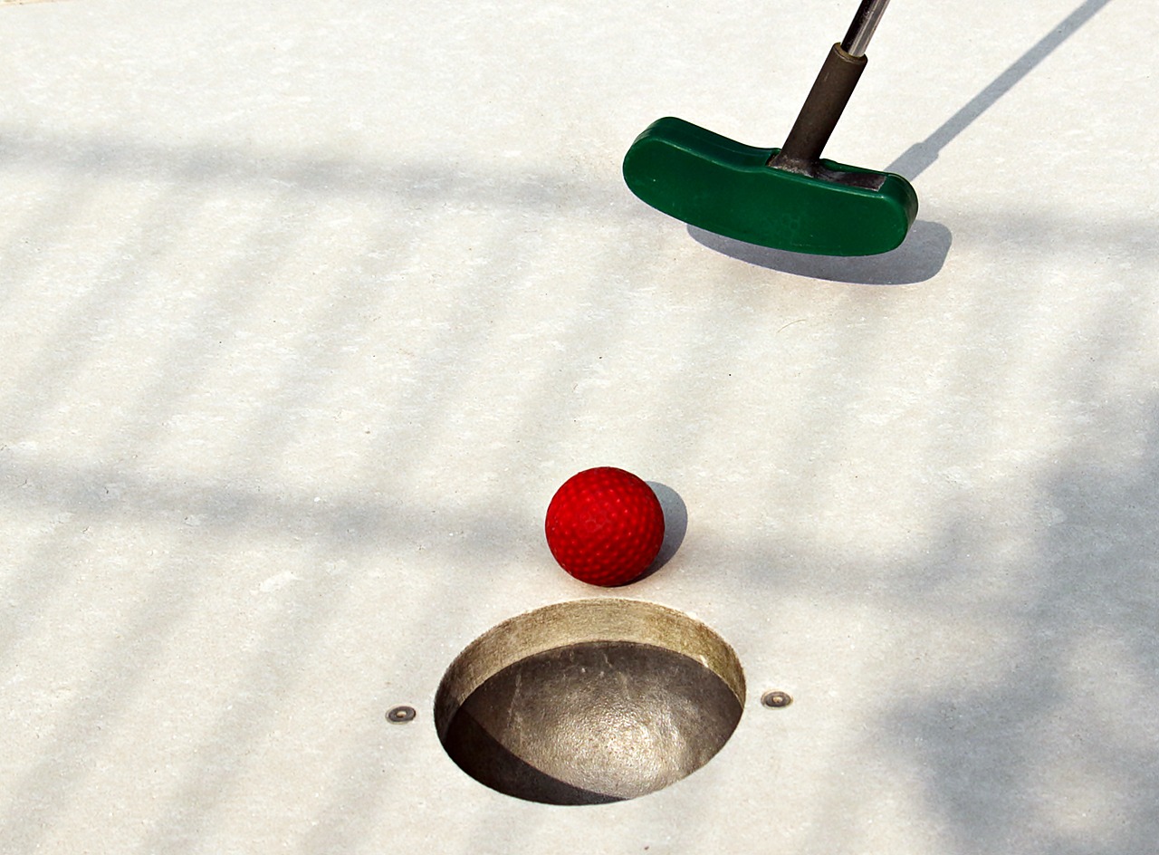 mini golf setup with green club and red ball