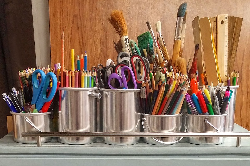 pencils pens and other craft items in metal cups