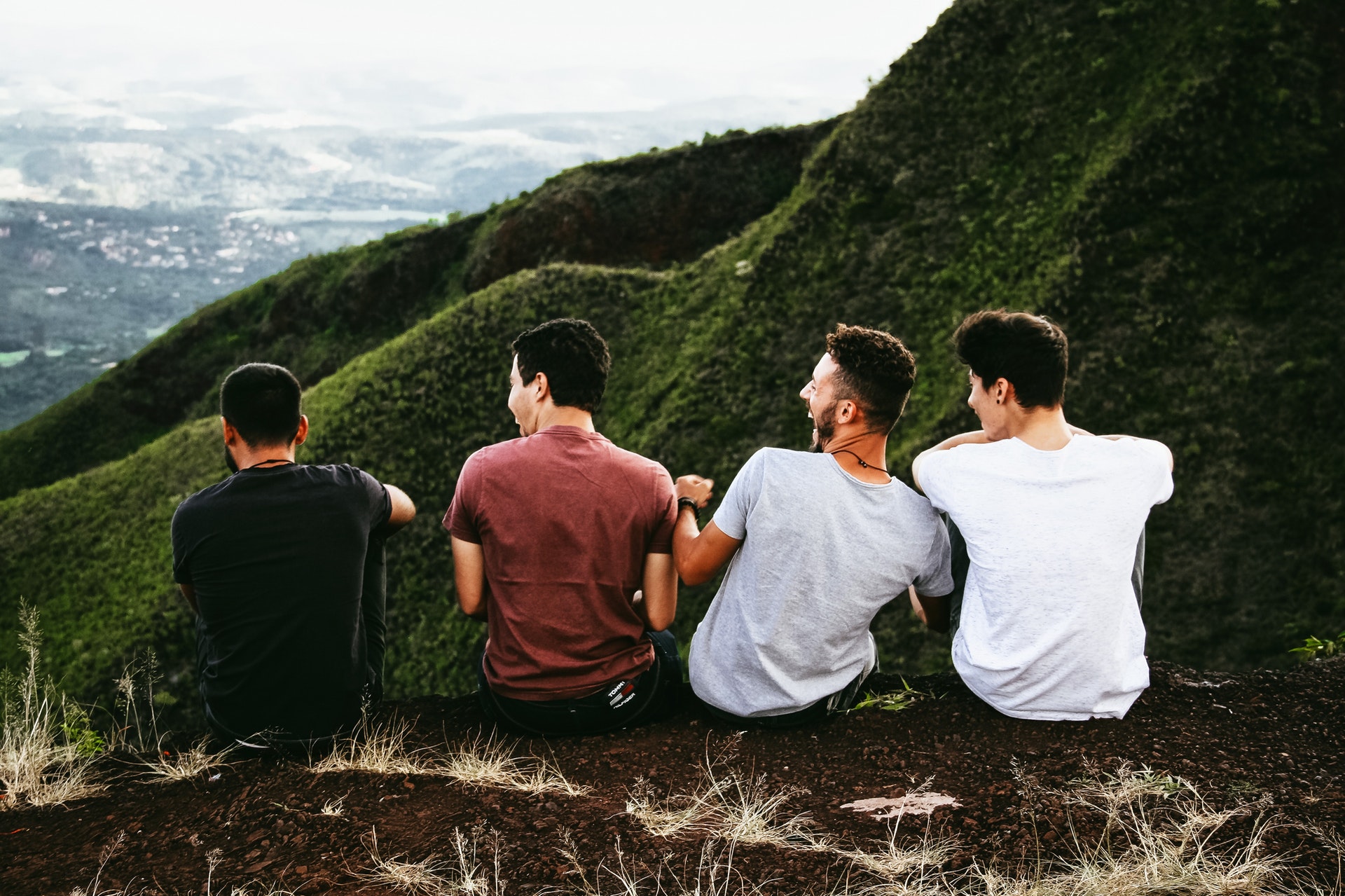 four guys sitting on a ledge