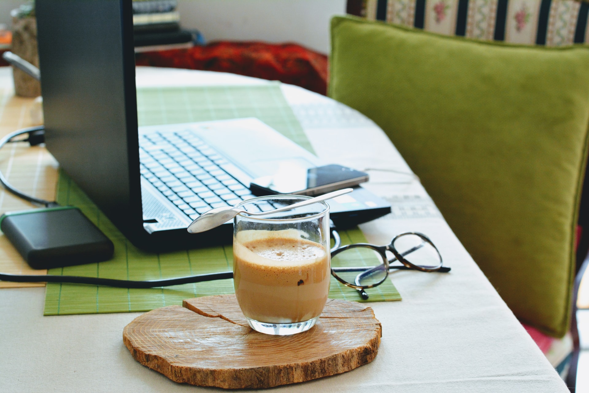laptop on table with glasses and coffee