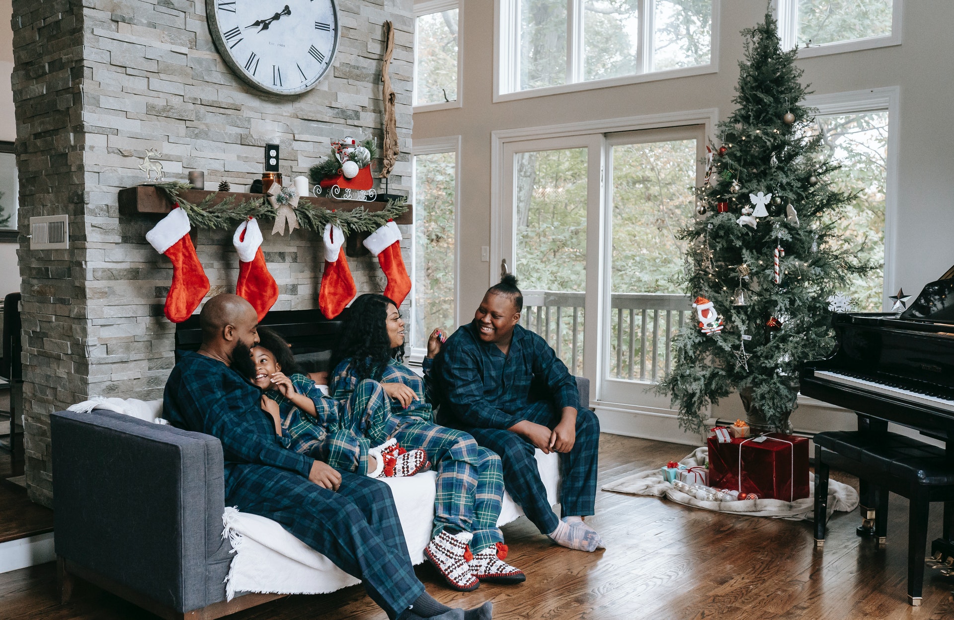people sitting by a fireplace and christmas tree