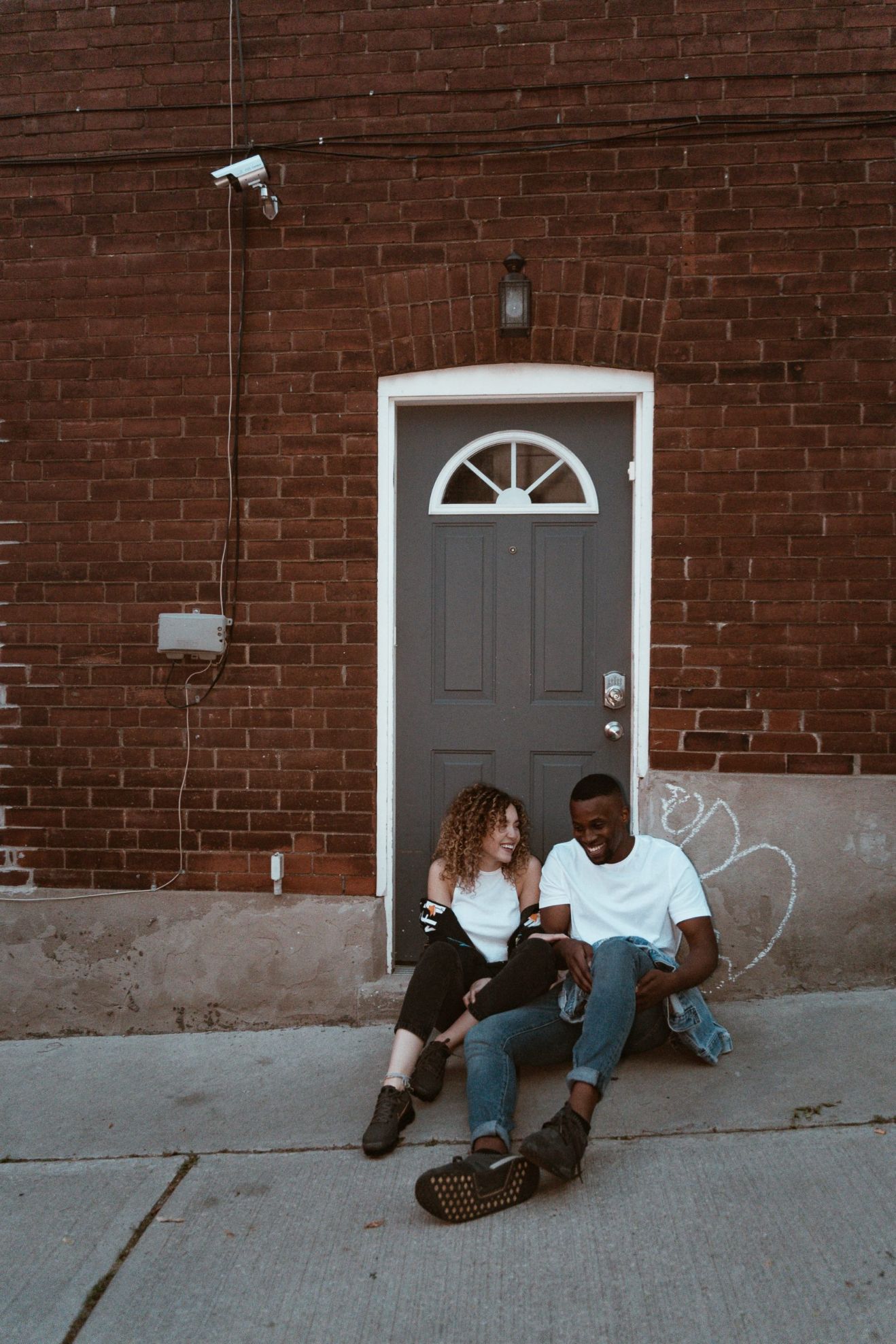 Couple Sitting in Front of a Doorway after a date night in Bend